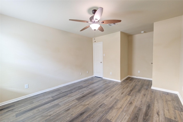 empty room featuring baseboards, ceiling fan, wood finished floors, and visible vents