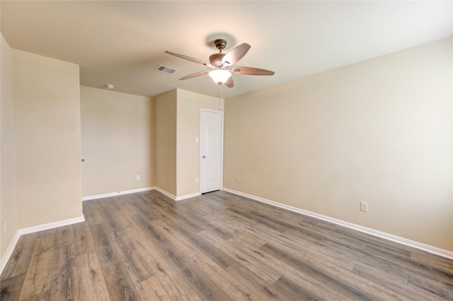 empty room featuring baseboards, ceiling fan, wood finished floors, and visible vents
