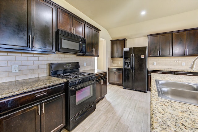 kitchen with tasteful backsplash, dark brown cabinets, a sink, black appliances, and lofted ceiling
