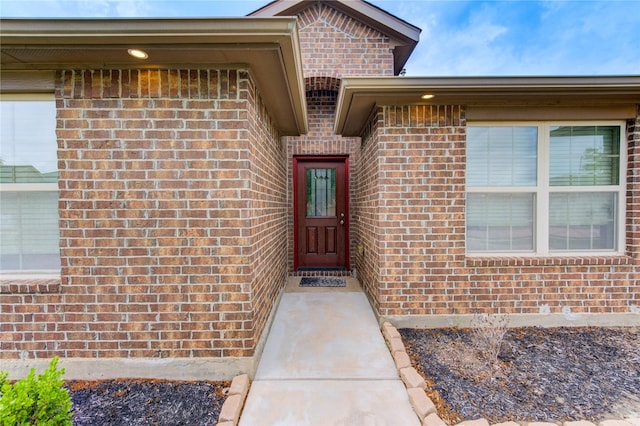 view of exterior entry with brick siding