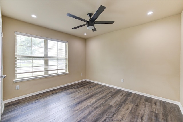 empty room featuring a healthy amount of sunlight, baseboards, a ceiling fan, and dark wood-type flooring
