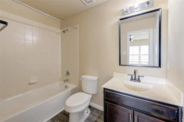 full bath featuring visible vents, vanity, wood finished floors, toilet, and shower / washtub combination