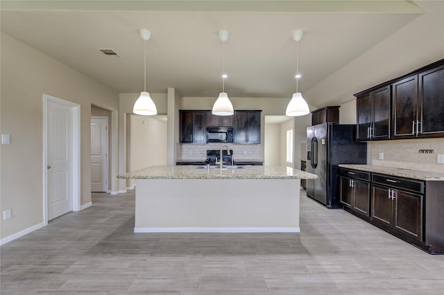 kitchen with visible vents, a sink, black appliances, and tasteful backsplash
