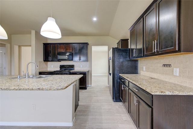 kitchen with pendant lighting, tasteful backsplash, dark brown cabinets, a sink, and black appliances