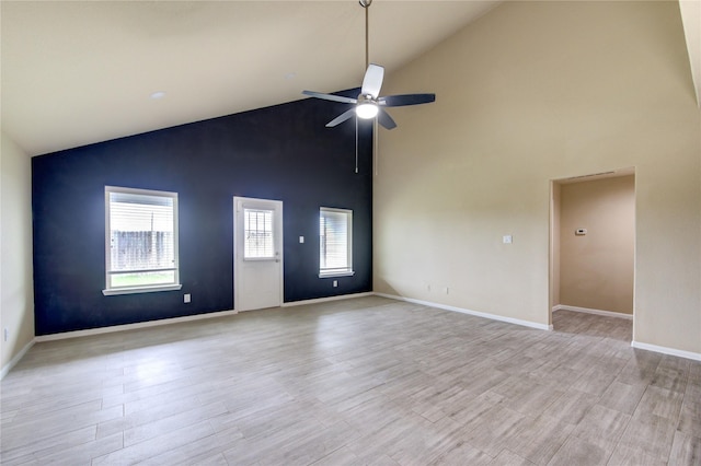 unfurnished room featuring baseboards, a ceiling fan, light wood-style flooring, and high vaulted ceiling