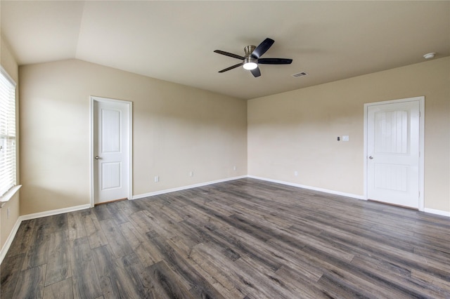 spare room with a ceiling fan, visible vents, lofted ceiling, and dark wood-type flooring