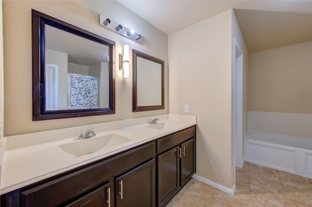 bathroom featuring double vanity, a sink, baseboards, and tile patterned flooring