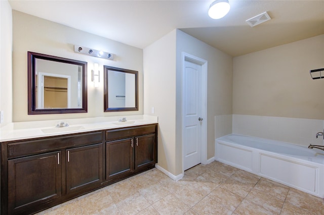 full bathroom with a sink, a garden tub, double vanity, and visible vents