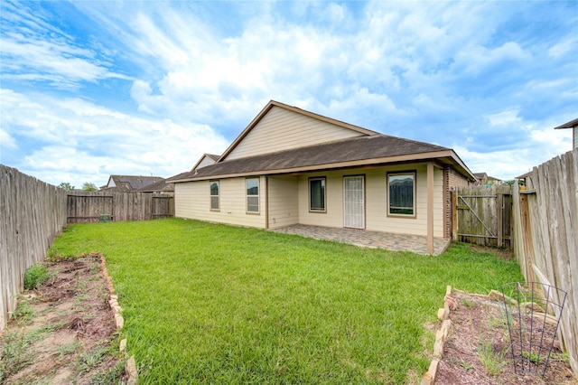 rear view of house featuring a lawn, a fenced backyard, and a patio area