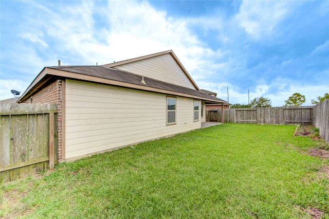 view of side of home with a yard and a fenced backyard