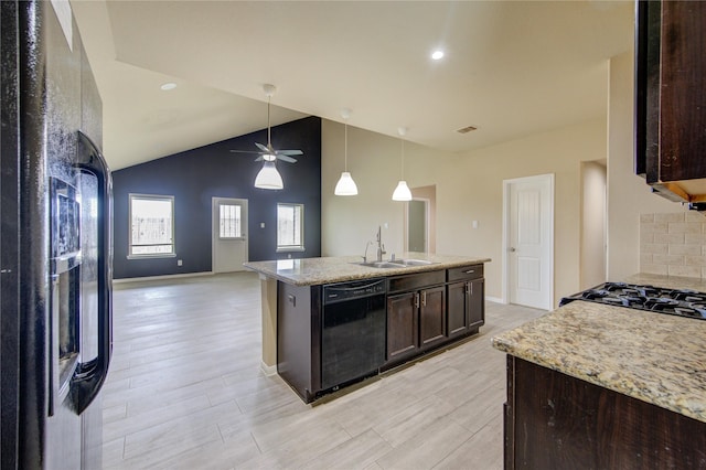 kitchen with dark brown cabinetry, a sink, a ceiling fan, open floor plan, and black appliances