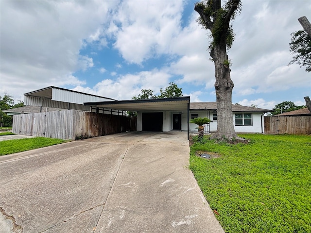 view of front of property featuring fence, a garage, an attached carport, a front yard, and driveway