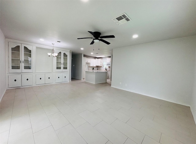 unfurnished living room with recessed lighting, baseboards, visible vents, and ceiling fan with notable chandelier