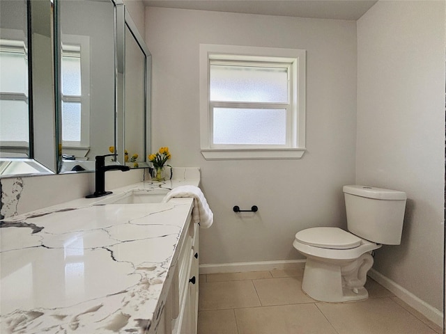bathroom featuring toilet, baseboards, tile patterned flooring, and vanity