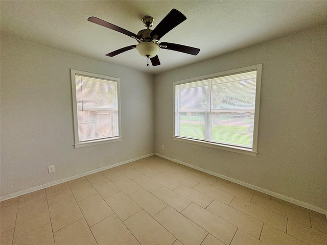 unfurnished room with a ceiling fan, baseboards, and light tile patterned floors