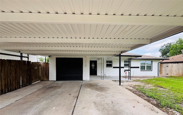 view of front of home with fence, an attached garage, an attached carport, and brick siding
