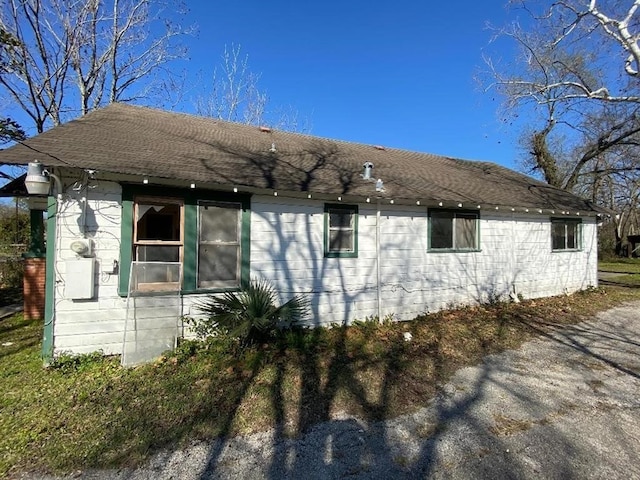 view of side of home featuring roof with shingles