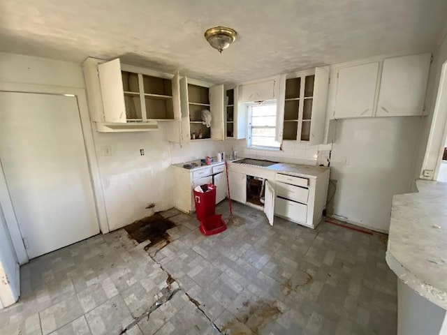 kitchen with open shelves, white cabinets, and light countertops