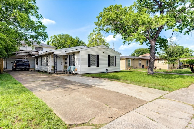 ranch-style house with a carport, a front yard, and concrete driveway