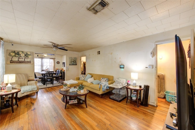 living area with visible vents, ceiling fan, and hardwood / wood-style flooring