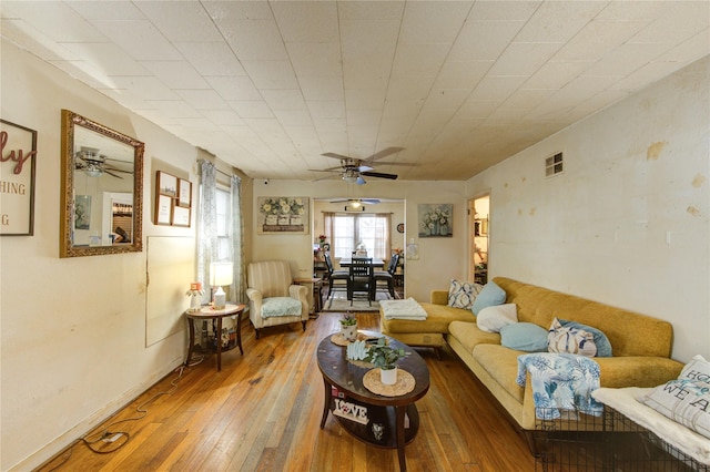 living room with baseboards, a ceiling fan, hardwood / wood-style floors, and visible vents