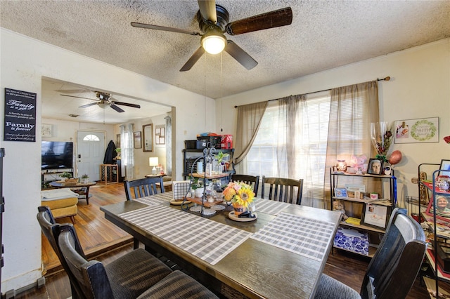 dining area with a textured ceiling, ceiling fan, and wood finished floors