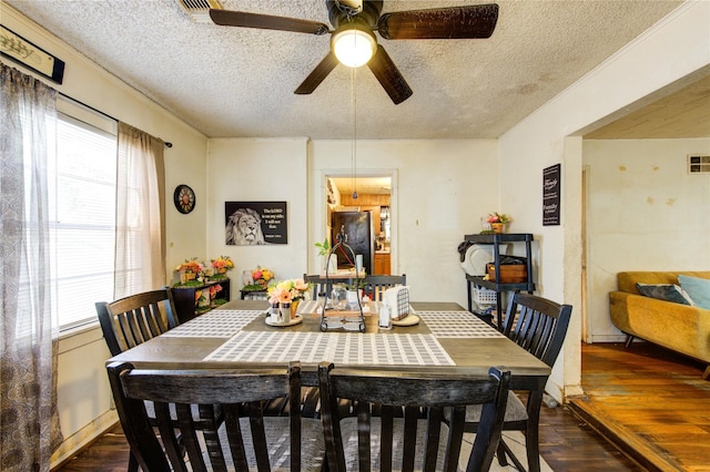 dining room featuring a textured ceiling, ceiling fan, and dark wood-type flooring