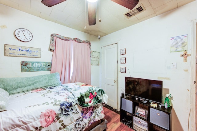bedroom with visible vents, a ceiling fan, and wood finished floors