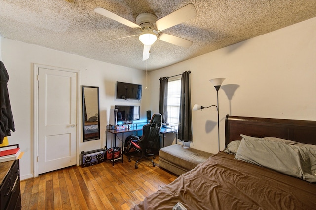 bedroom featuring a ceiling fan, a textured ceiling, and hardwood / wood-style floors