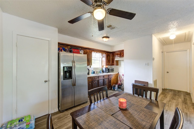 dining space featuring attic access, a textured ceiling, and wood finished floors