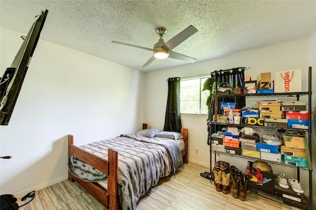 bedroom featuring baseboards, a ceiling fan, and a textured ceiling