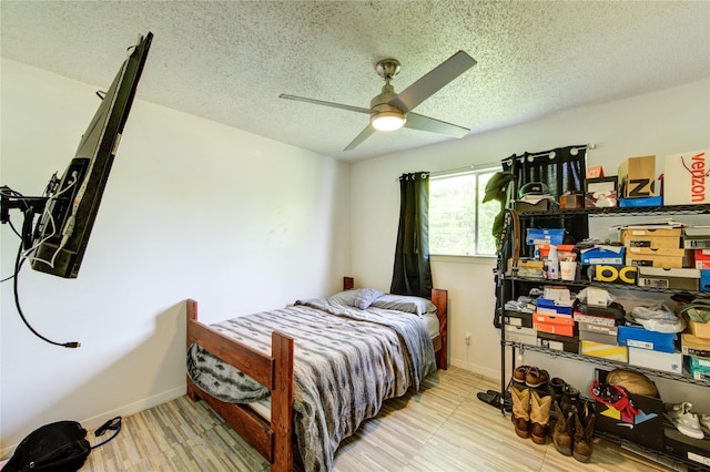 bedroom with baseboards, a ceiling fan, and a textured ceiling