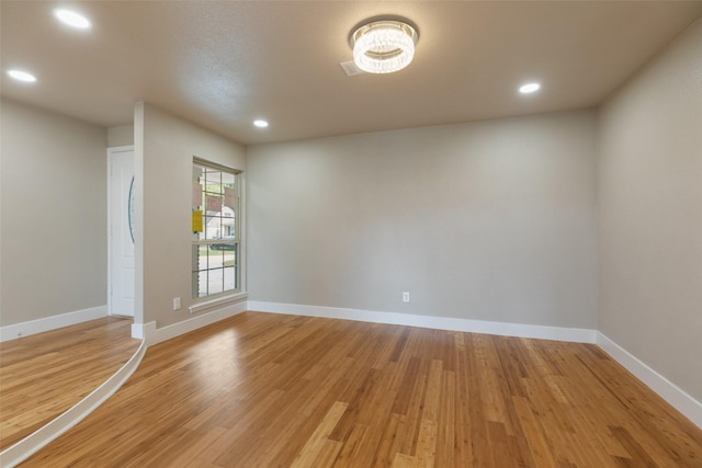 unfurnished room featuring recessed lighting, light wood-style flooring, and baseboards