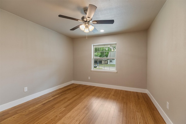 empty room featuring baseboards, ceiling fan, and light wood-style flooring