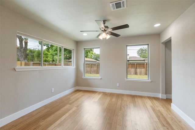 empty room with visible vents, baseboards, ceiling fan, and light wood-type flooring