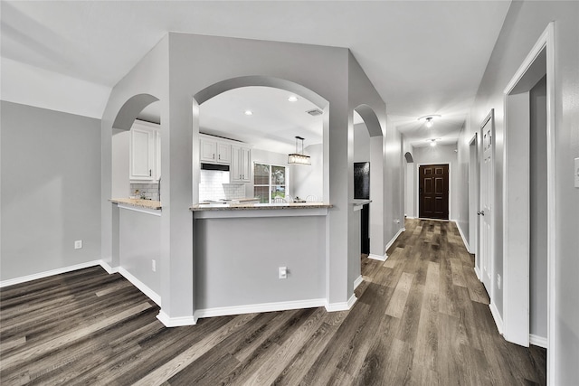 hallway with baseboards and dark wood-type flooring