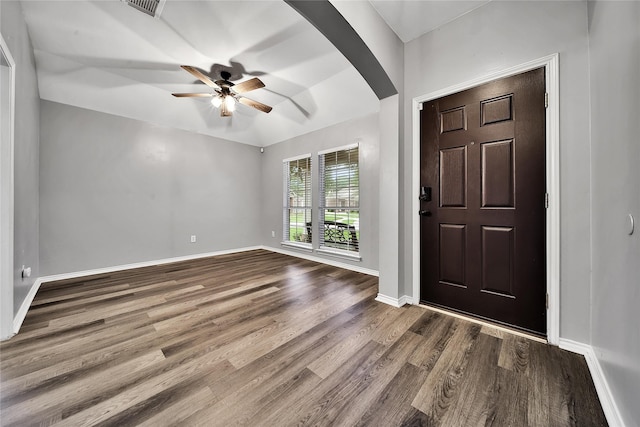 foyer featuring ceiling fan, visible vents, arched walkways, dark wood finished floors, and baseboards
