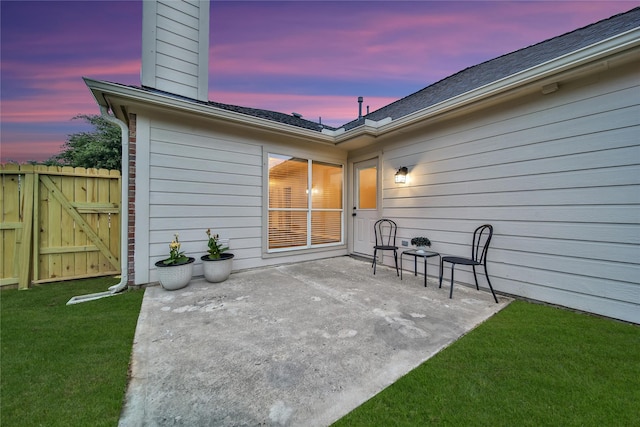 patio terrace at dusk with fence and a lawn