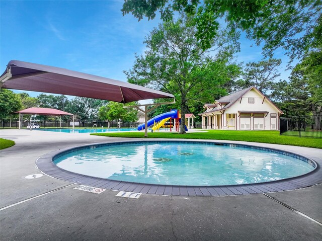 community pool featuring fence, a yard, and playground community