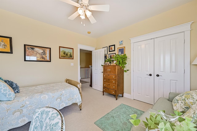 bedroom featuring a ceiling fan, light colored carpet, and a closet