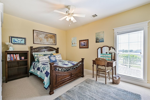 bedroom featuring baseboards, visible vents, a ceiling fan, and light colored carpet