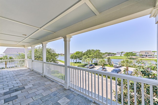 view of patio / terrace with a residential view and a water view