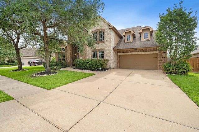 traditional-style home with fence, concrete driveway, a front lawn, and stone siding