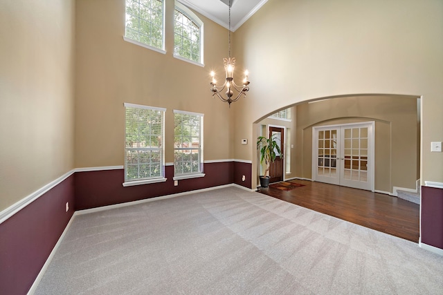 11014 Via Capri Ct, Richmond, TX 77406 - carpeted spare room featuring a chandelier, arched walkways, crown molding, a towering ceiling, and baseboards