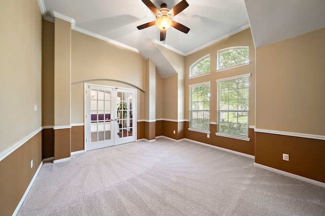 carpeted empty room featuring ceiling fan, a high ceiling, french doors, baseboards, and ornamental molding