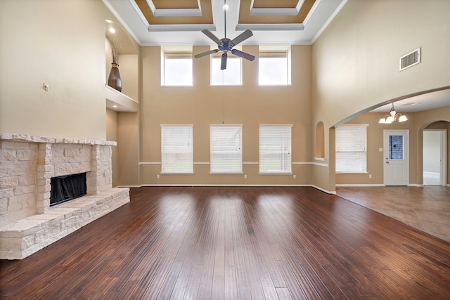 11014 Via Capri Ct, Richmond, TX 77406 - unfurnished living room with a ceiling fan, a high ceiling, a stone fireplace, arched walkways, and hardwood / wood-style floors