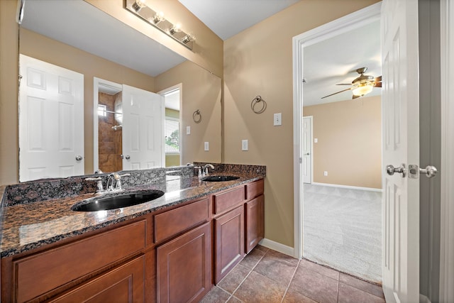 bathroom featuring baseboards, a sink, ceiling fan, and double vanity