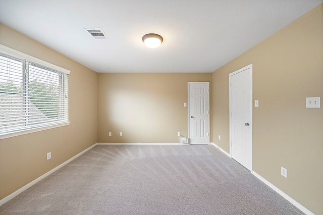 empty room with visible vents, carpet flooring, and baseboards