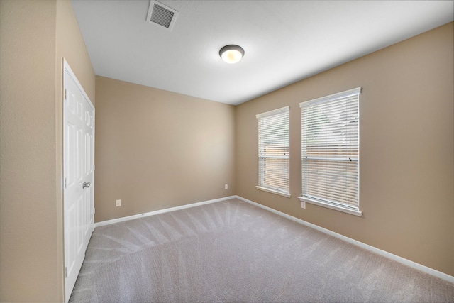 empty room featuring baseboards, carpet, and visible vents