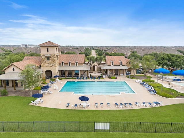 pool with a patio, fence, and a yard